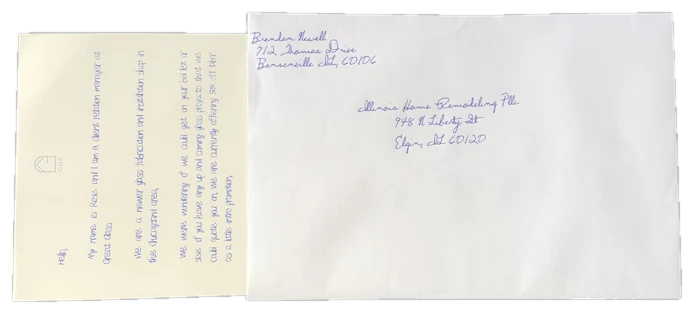 A handwritten letter sliding out of a hand-addressed envelope, landscape orientation