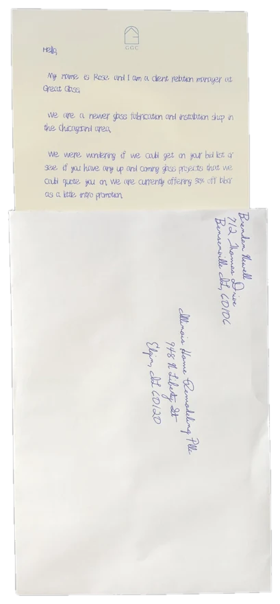 A handwritten letter sliding out of a hand-addressed envelope, portrait orientation