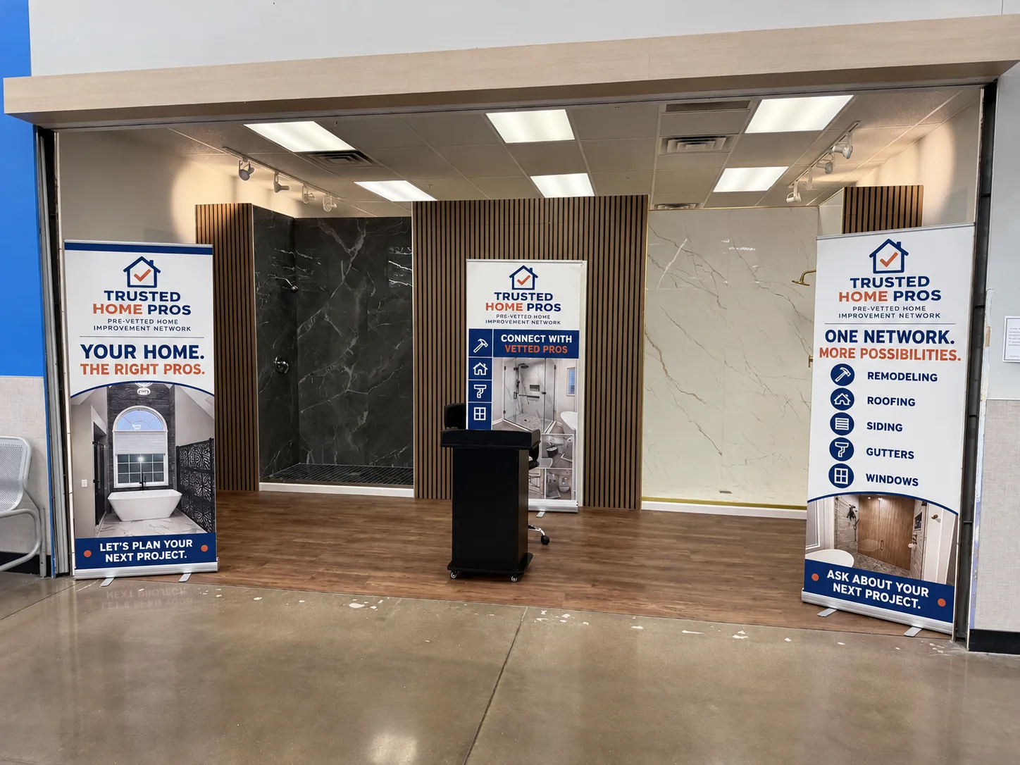The Trusted Home Pros display at a Walmart: three pull-up banners in front of two shower displays